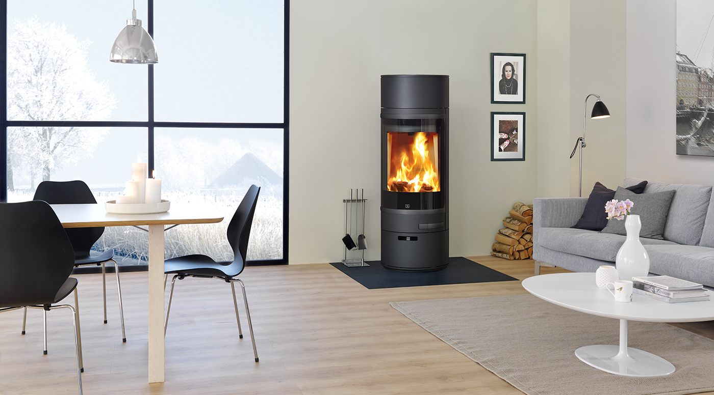 Scan 85-1 wood burning stove in black, in a living room setting- stove lit